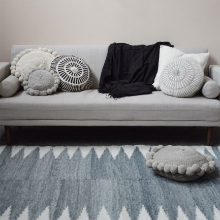 Coussin rond à pompons gris