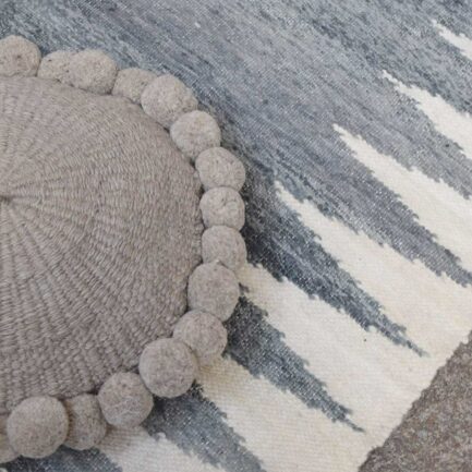 Coussin rond à pompons gris