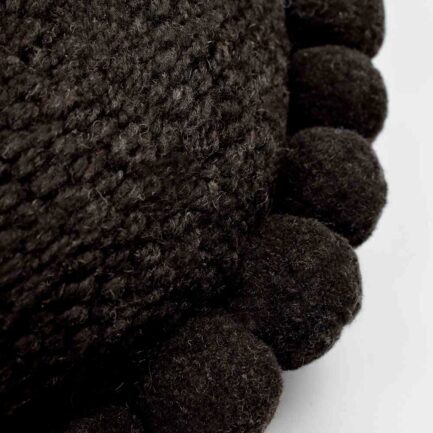 Coussin rond à pompons noir